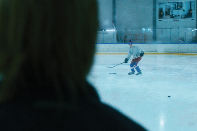 Ung gutt spiller hockey alene mens treneren ser på. Illustrasjonsbilde